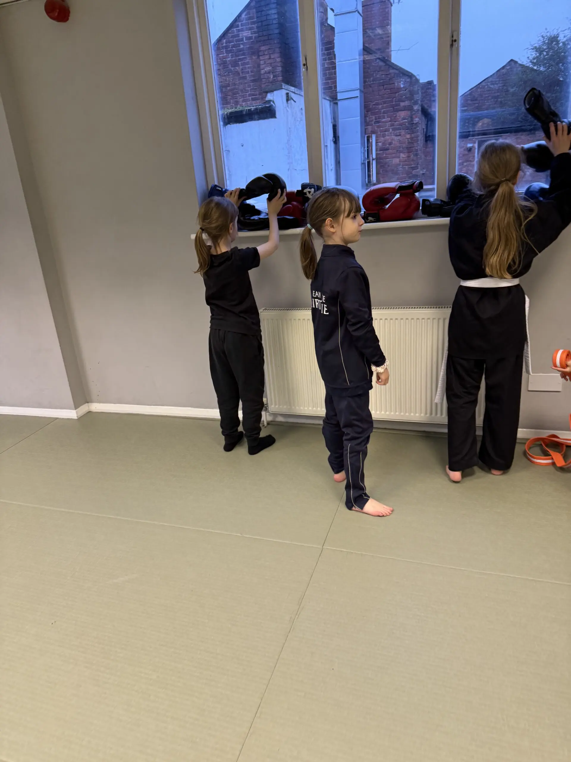 A martial arts school helps prepare children for everyday life by improving their physical fitness, coordination, and social skills through karate lessons, fostering self-confidence as students progress toward a black belt while encouraging and supporting other children.