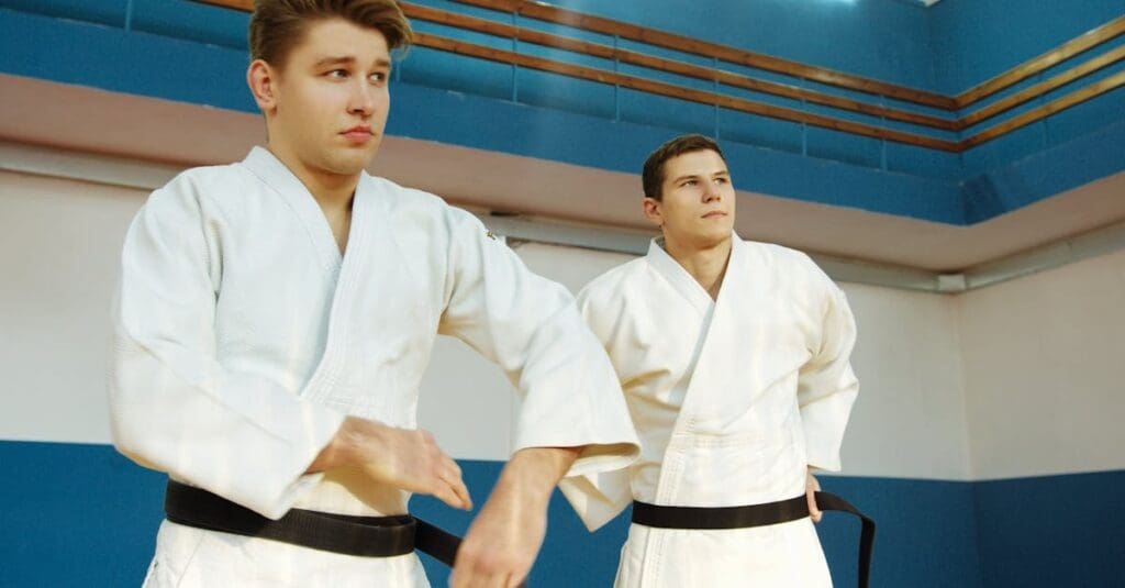 Two young male black belts standing focused and ready during a teens karate lesson.