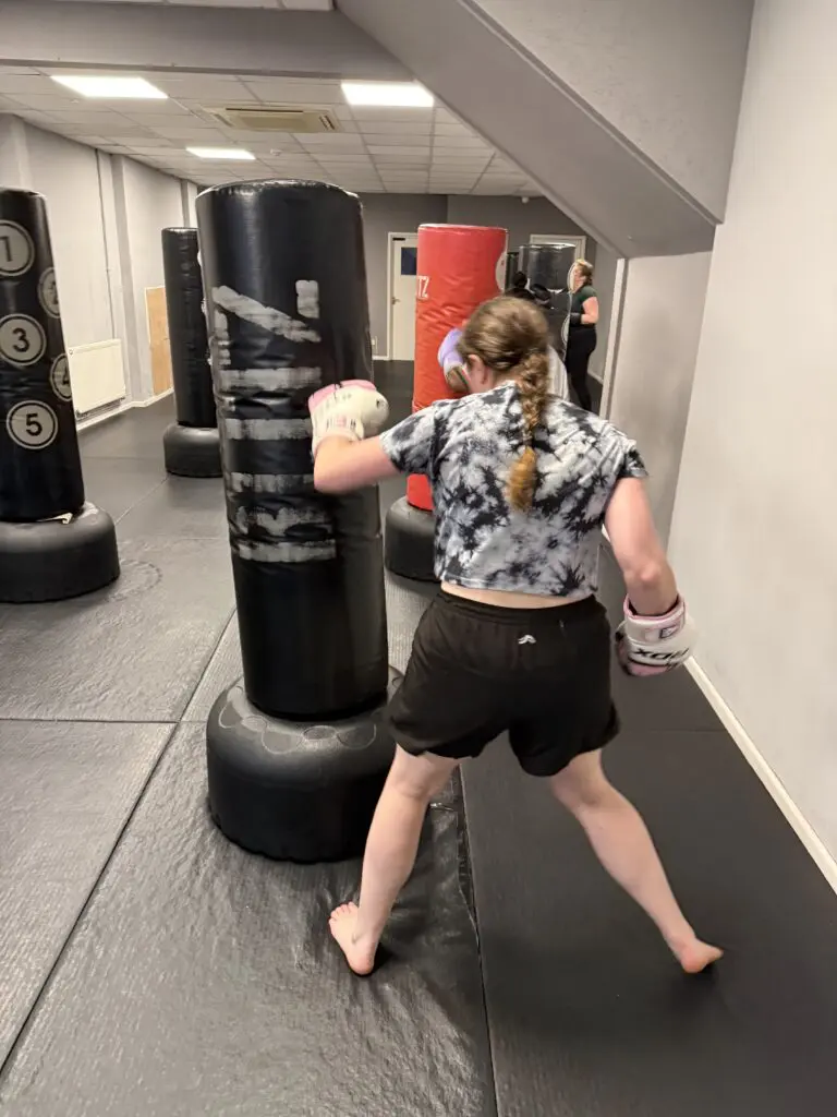Woman hitting a heavy bag during fitness kickboxing training in Cheltenham at Cheltenham Martial Arts