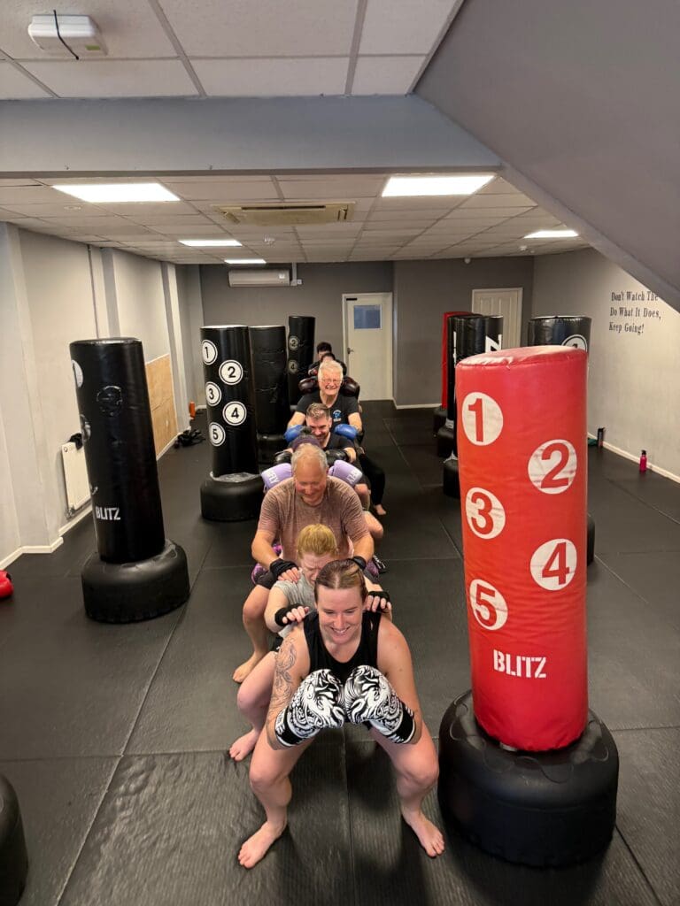 People doing conditioning exercises during strength rounds at fitness kickboxing class in Cheltenham